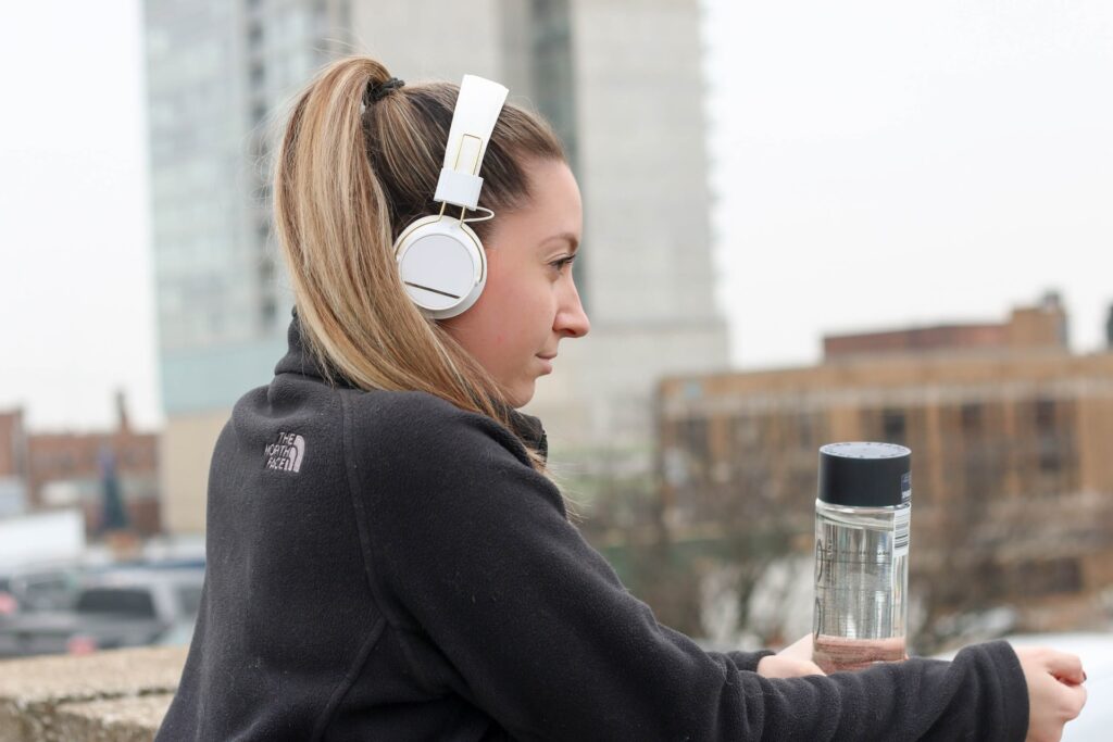 Girl with headphones looking over cityscape