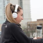 Girl with headphones looking over cityscape