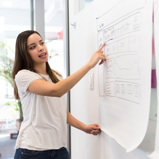 Lady at flipchart whiteboard showing data